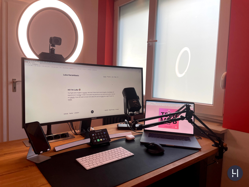 Desk with camera, ring light, display, microphone with an arm, stream deck and MacBook.